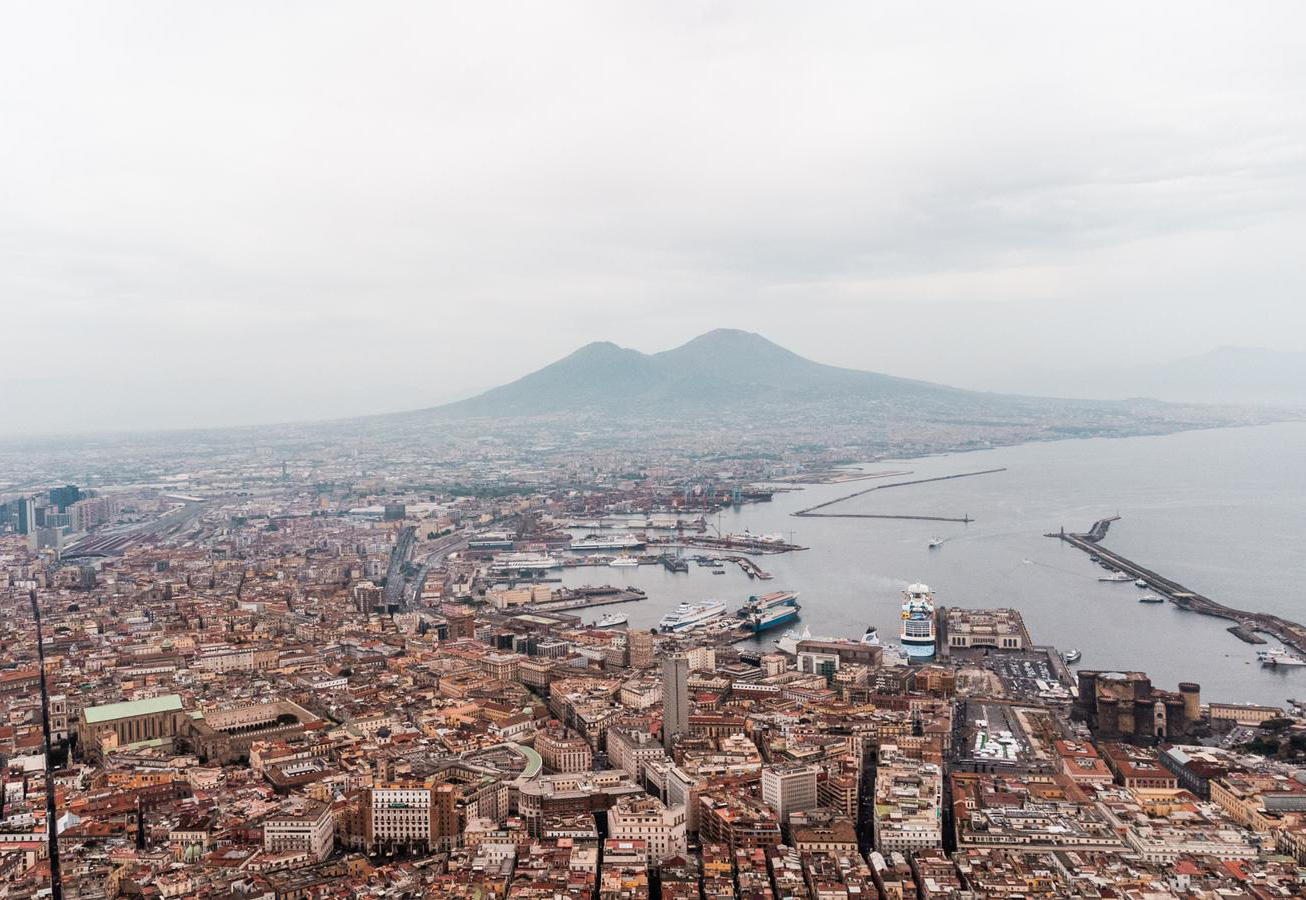 Aerial view of Naples, Italy, showcasing the vibrant cityscape, coastline, and historic architecture from above.